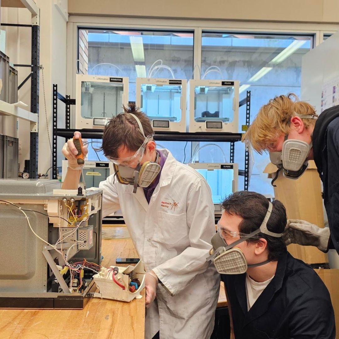 Team disassembling a microwave